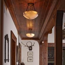 Tuscany™ Family Alabaster Pendants Illuminate the Hall of a Rustic Residence